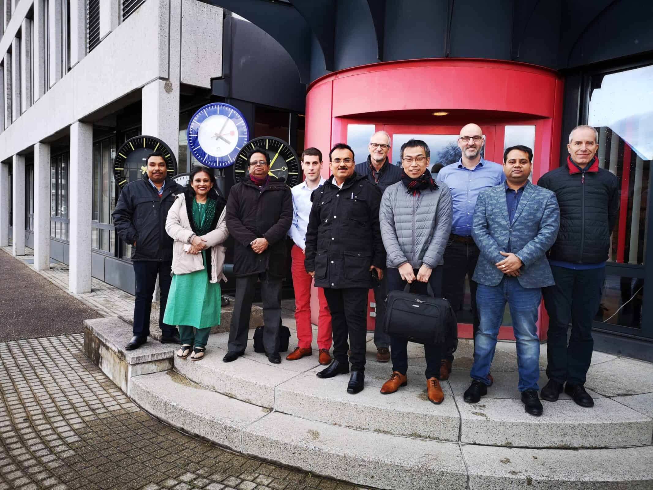 Senior Delegation representing the Dhaka Metro officials in Sumiswald with MOBATIME Team Members in front of MOBATIME Building, Analogue clocks behind left