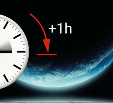 A stylised image of a MOBATIME clock against a background representing outer space, with an arrow marked in red and the text "+1h" indicating a time changeover