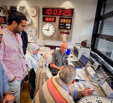 Engineers and project representatives observe live testing of master and slave clocks during the Factory Acceptance Test (FAT) for Egypt’s High-Speed Rail project at Moser-Baer headquarters, with synchronized time displays visible in the background.
