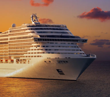 A ship entering a harbour at dusk