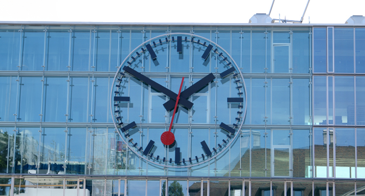 Large Swiss railway station clock suspended from the office building at Aarau railway station